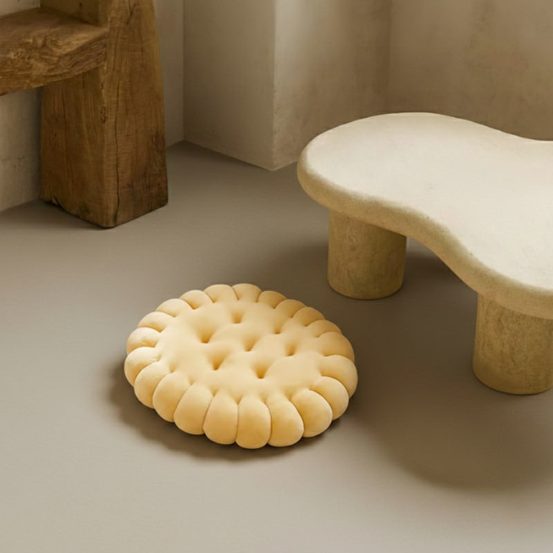 Yellow latest cushion design on a neutral floor with a stone-like stool in the background.