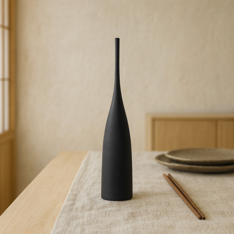 Long wabi sabi vase on a table with a neutral background
