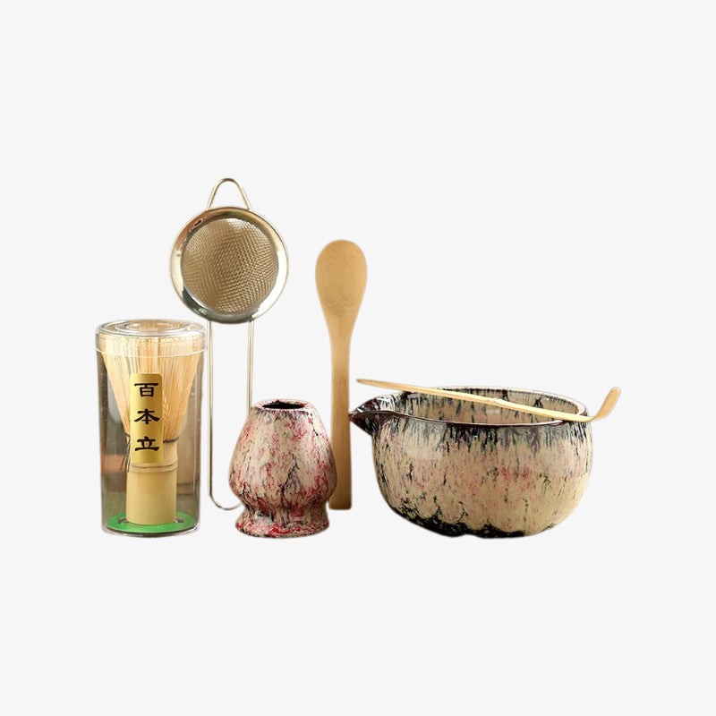 matcha green tea ceremony set​ with a whisk, strainer, spoon, and pot on a white background