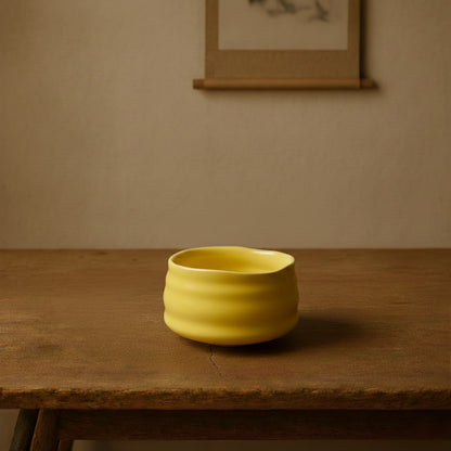 Yellow matcha in green tea on a brown surface with a matching brown background