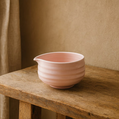 Pink matcha late​ ceramic bowl on a gray surface with a neutral background