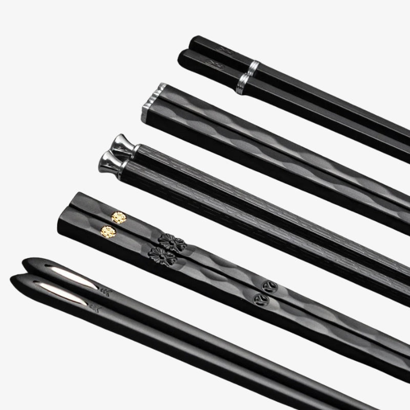 Set of black metal japanese chopsticks with decorative ends on a white background