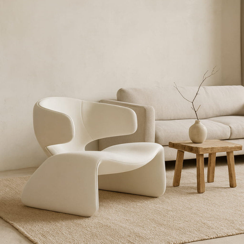 Modern mid century lounge beige chair​ and sofa in a minimalistic living room with a wooden side table.