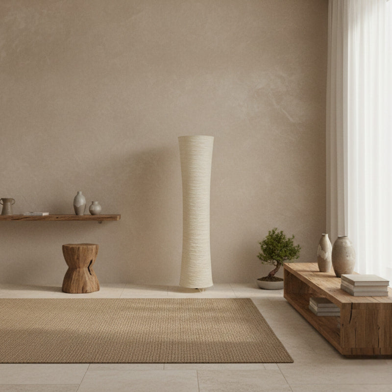 Modern interior with wooden furniture, a tall minimalist floor lamp, and decorative items against a beige wall.