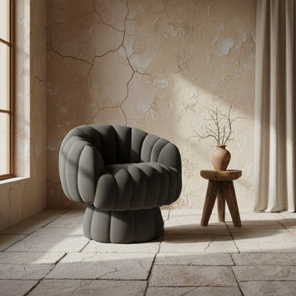 Dark gray swivel modern lounge chair in a room with a wooden stool and vase.