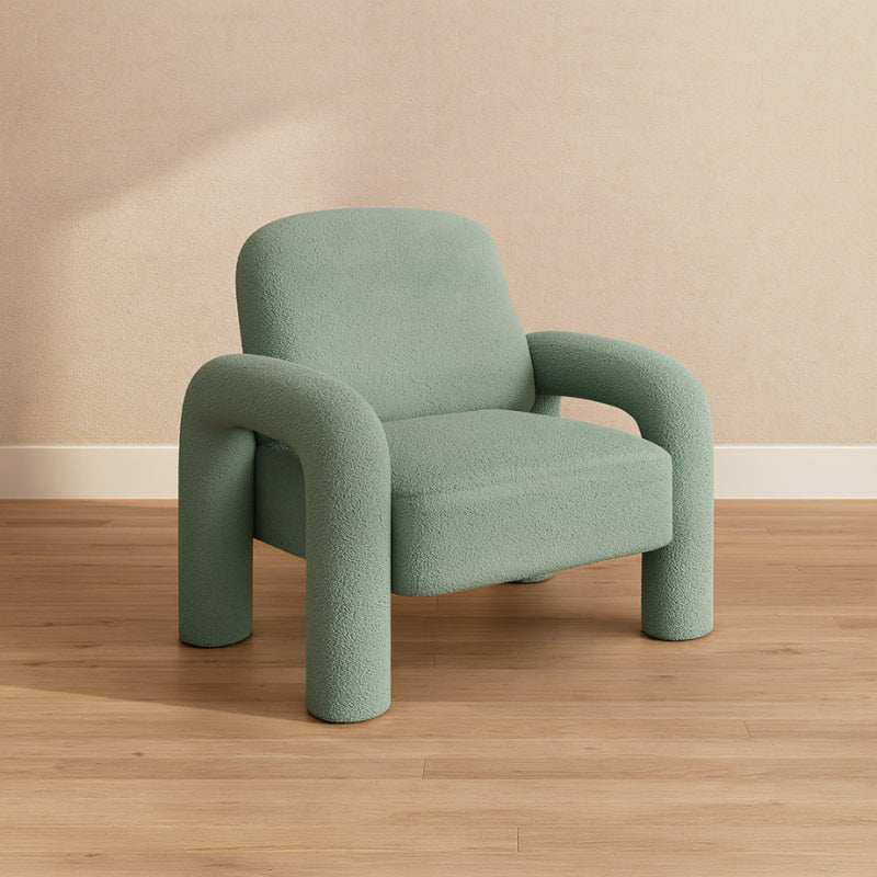 Green nice reading chair on a wooden floor with a beige wall background