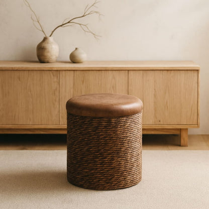 wabi sabi brown storage ottoman in front of a wooden cabinet with decorative vases.
