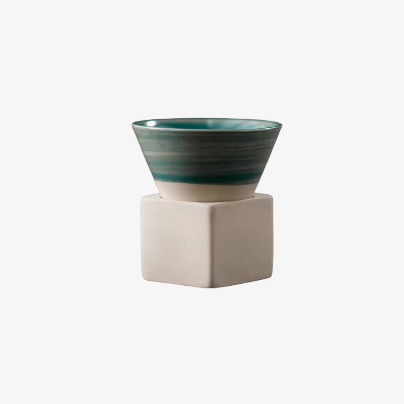 wabi sabi coffee cup on a beige hexagonal stand against a white background