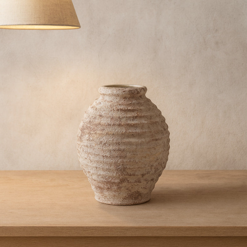 Rustic wabi sabi jars on a wooden table with a woven pendant light and plates in the background.