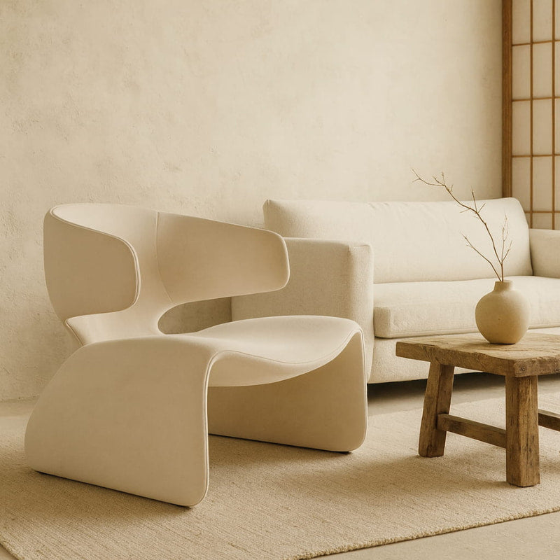 wabi sabi mid century modern​ chair and sofa in a minimalistic room with wooden table and vase.