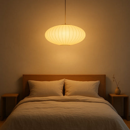 Bedroom with a wooden headboard, two pillows, and a hanging wabi sabi pendant light australia​