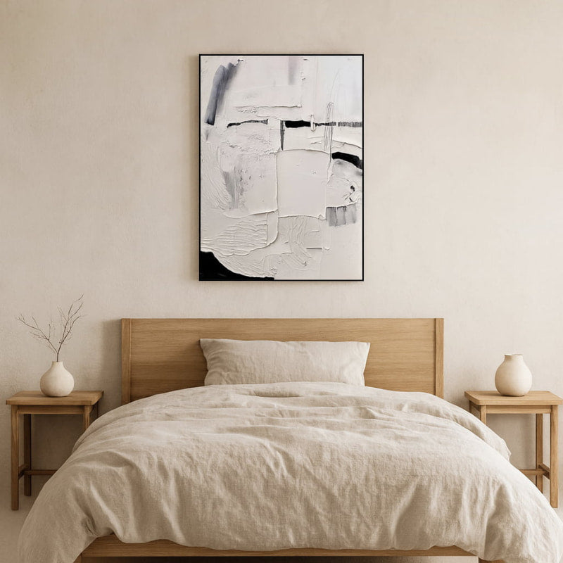 Bedroom with wooden bed, beige bedding, and a wabi sabi style painting.