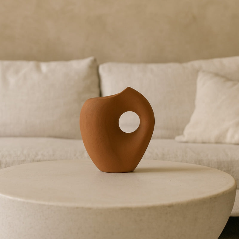 wabi sabi style vase on a beige table with a beige sofa in the background
