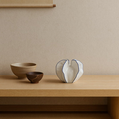 white ceramic vase large​ on a wooden table with wabi sabi bowls
