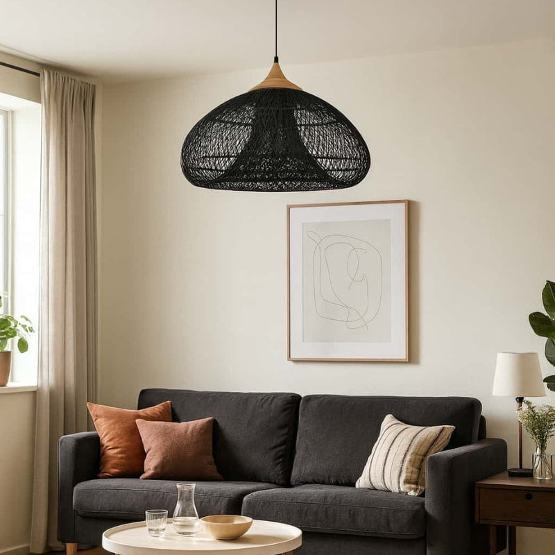 Modern living room with a dark gray sofa, wooden coffee table, and wicker lighting pendant.