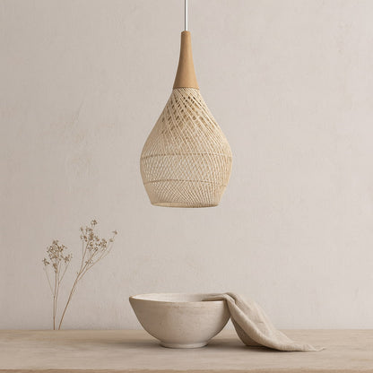Wicker pendant light​​ hanging above a ceramic bowl with a cloth on a neutral background