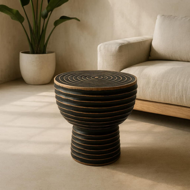Decorative wooden painted stool​ in a living room setting with a beige sofa and plant.