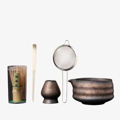 Zens matcha set​ Japanese tea-making tools including a glass container, whisk, spoon, and large pot on a white background.